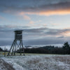 A photo of a hunting stand in a snowy field.