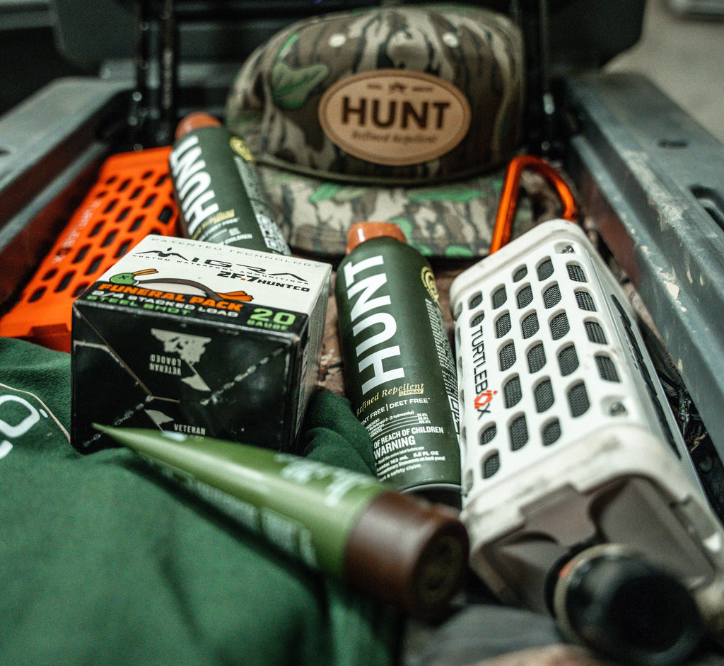 A photo of HUNT Refined Repellent among other hunting equipment.